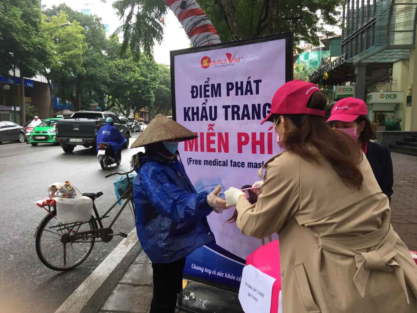 Người đi đường tích cực nhận khẩu trang miễn phí từ nhân viên Du Lịch Việt tại Hà Nội