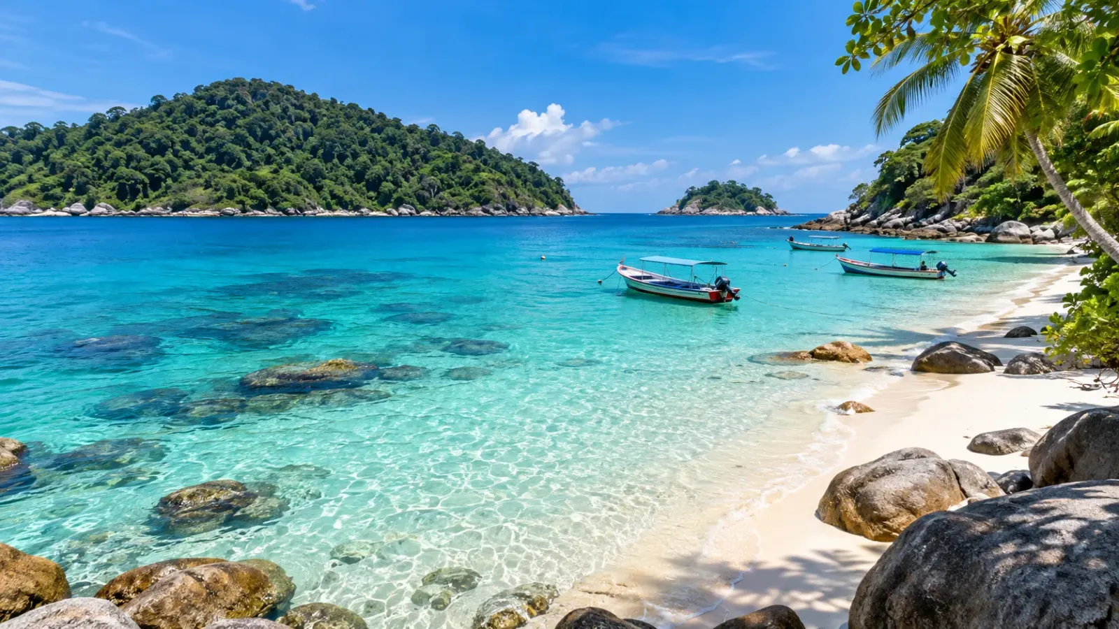 Bãi biển cát trắng với làn nước xanh và những chiếc thuyền tại quần đảo Perhentian, Malaysia.