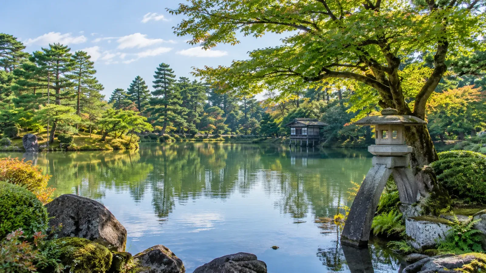 Cảnh quan vườn Kenrokuen tại Kanazawa với cây xanh hồ nước và lối đi truyền thống Nhật Bản