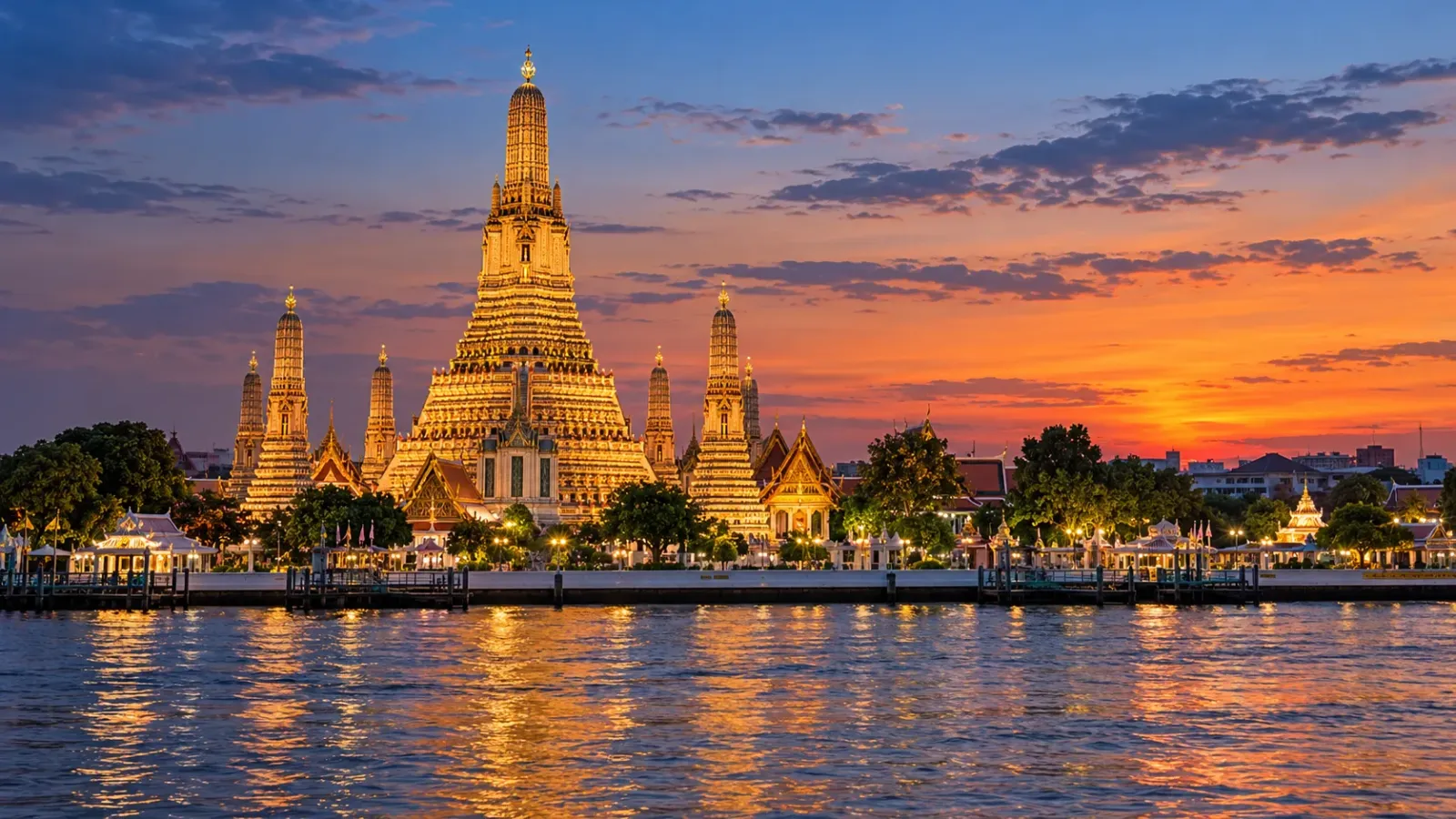 Chùa Wat Arun tại Bangkok với tháp prang được chiếu sáng bên sông Chao Phraya lúc chạng vạng.