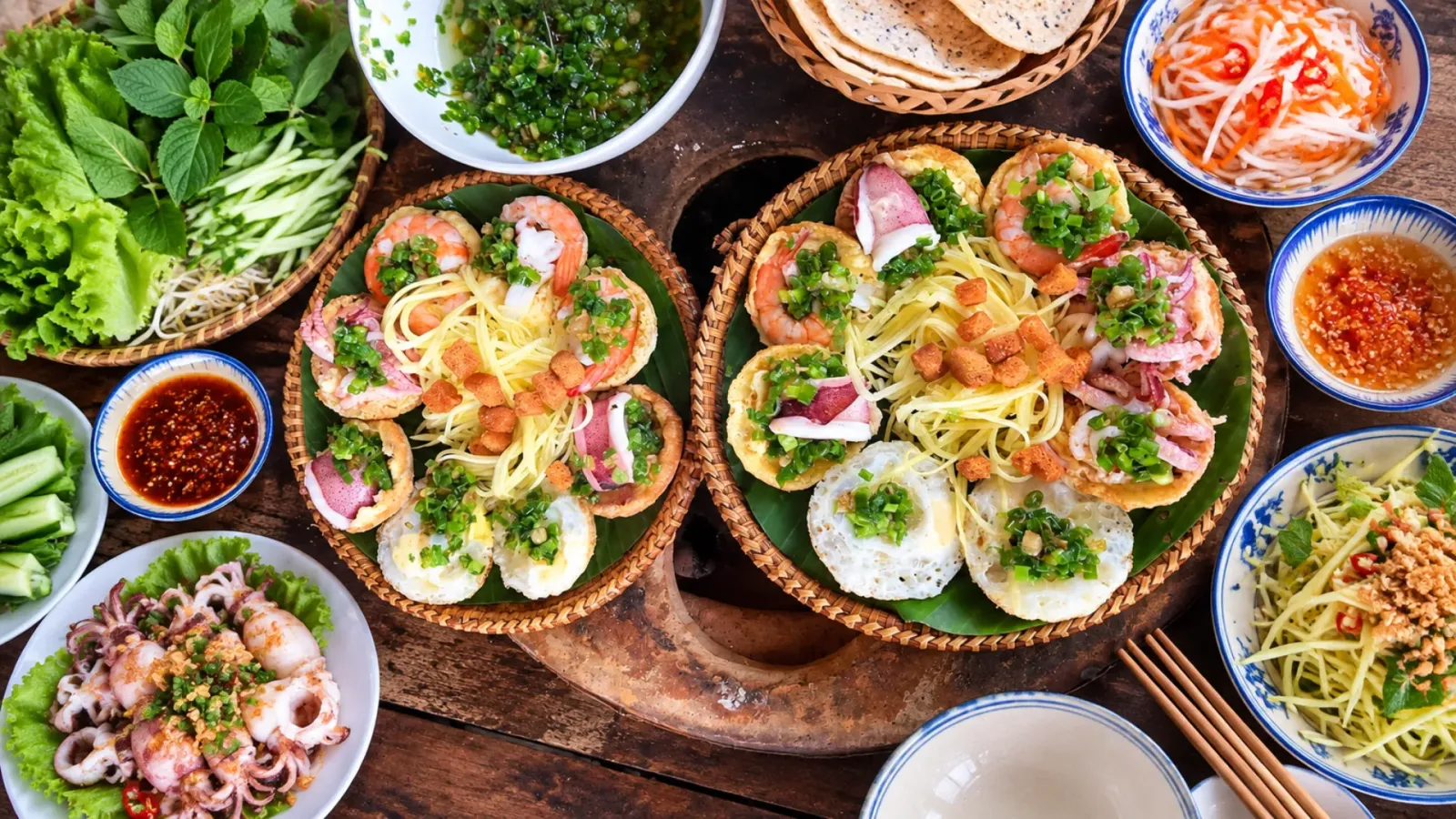 Đĩa bánh căn Phan Rang ăn kèm rau sống, nước chấm