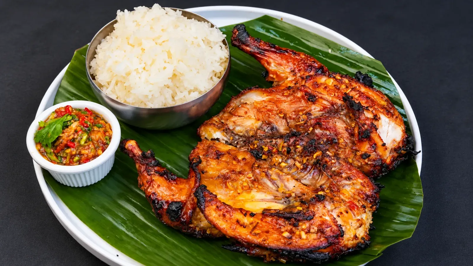 Gà nướng Gai Yang kiểu Thái với lớp da vàng nâu, ăn kèm xôi nếp và nước chấm