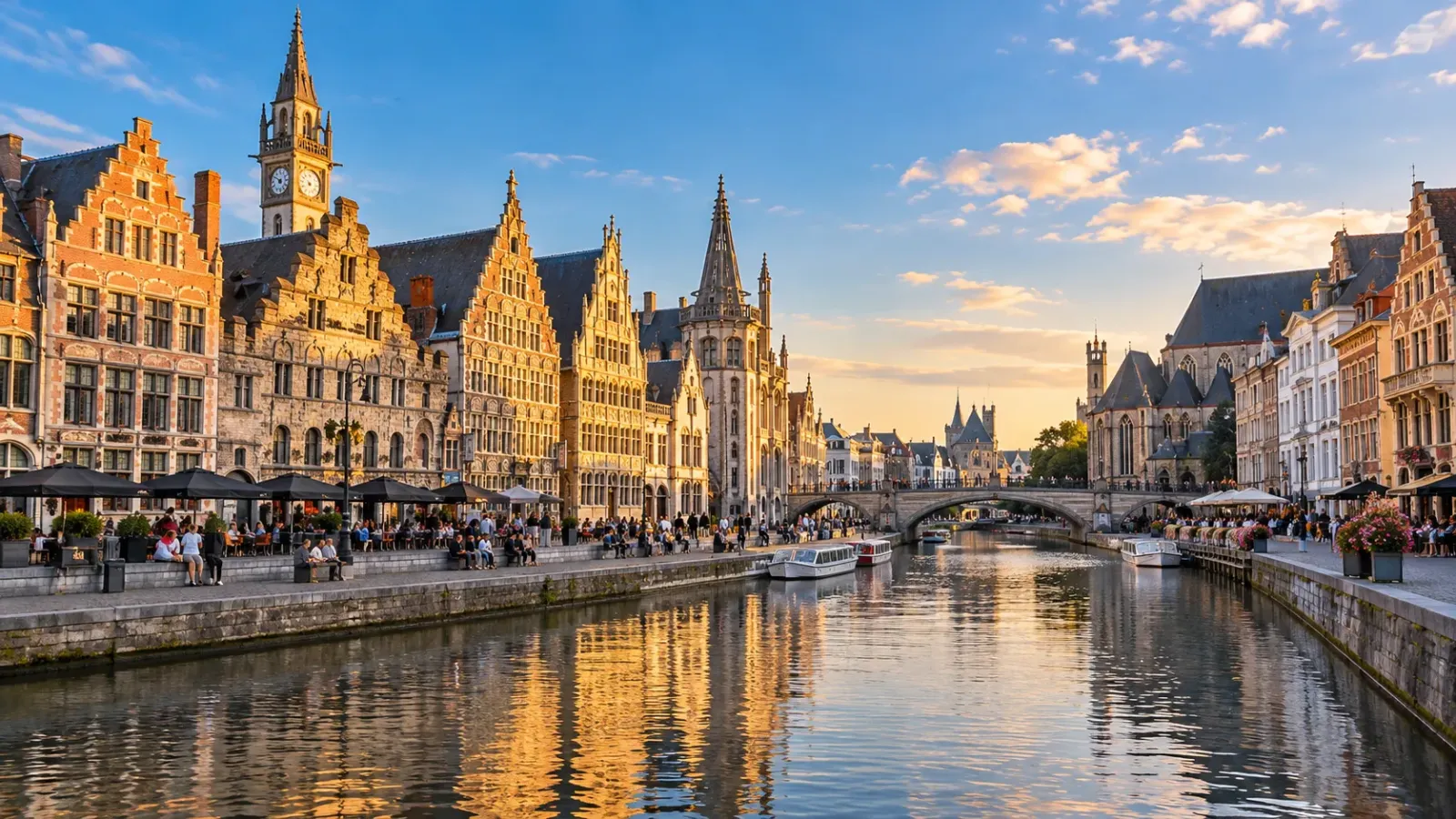 Kênh đào Bruges với dãy nhà cổ ven sông, mái ngói, tháp nhà thờ và một chiếc thuyền du lịch.