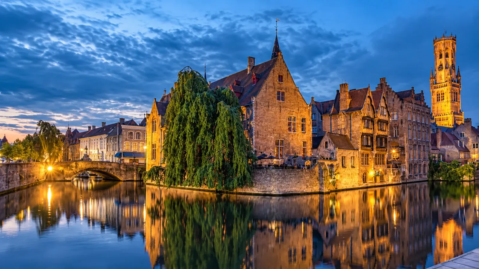 Kênh đào Bruges với những ngôi nhà cổ phản chiếu trên mặt nước trong ánh sáng chiều