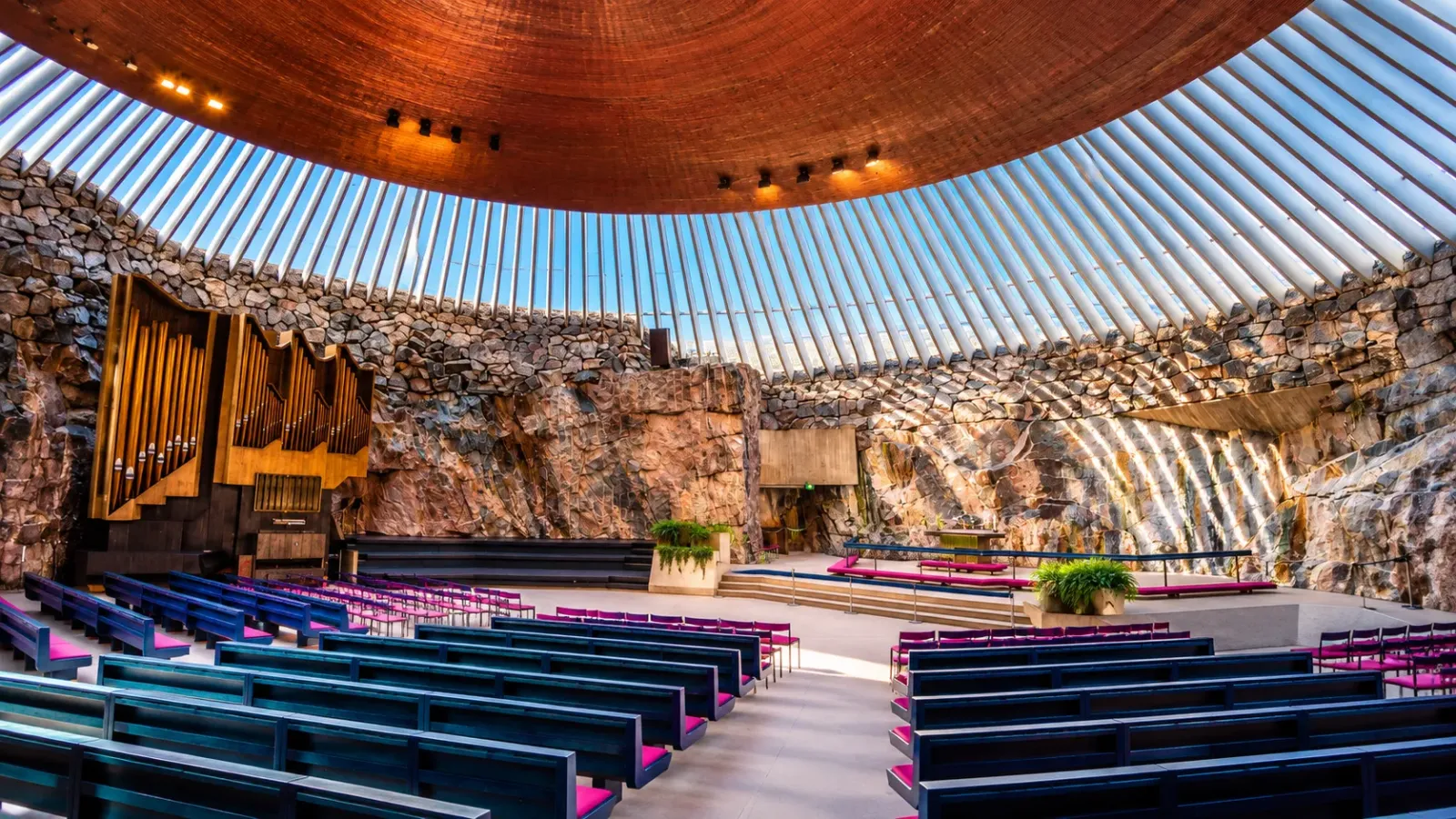 Không gian bên trong nhà thờ Temppeliaukio với tường đá và mái vòm tại Helsinki