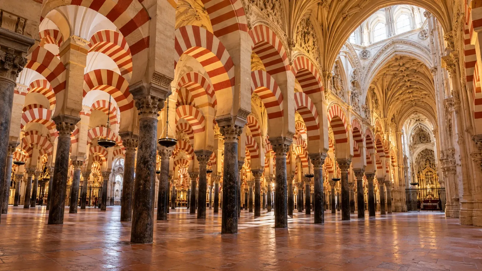 Không gian nội thất Mezquita Catedral Cordoba với các hàng cột đá và vòm sọc đỏ trắng 