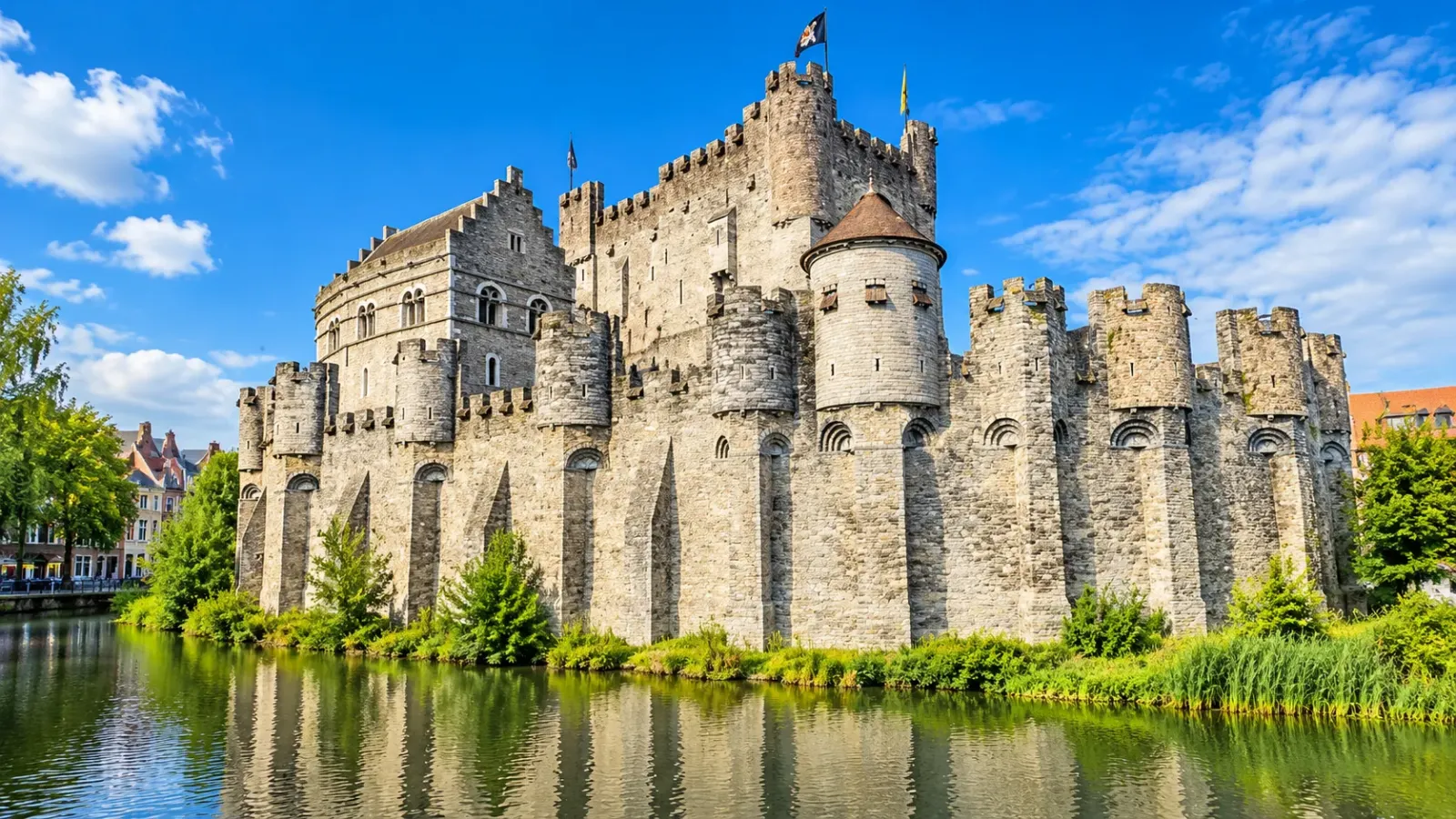 Lâu đài Gravensteen tại Ghent với tường thành bằng đá, tháp phòng thủ và hào nước.