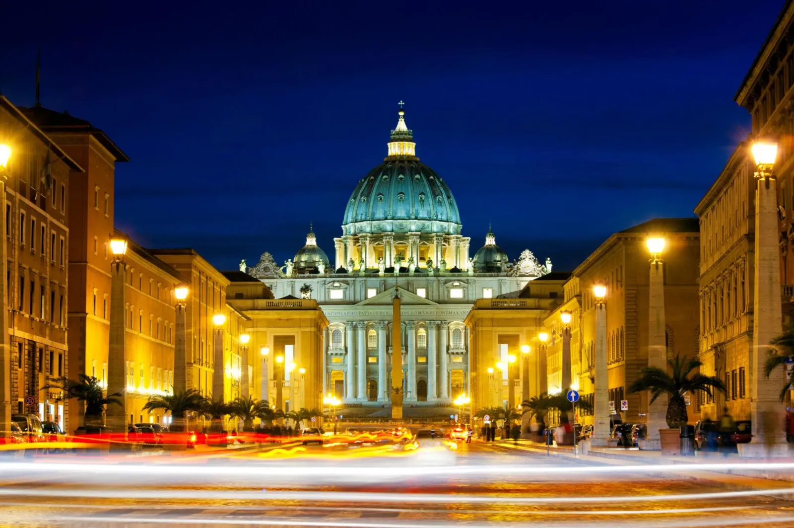 Mặt tiền và mái vòm Vương cung thánh đường Thánh Phêrô tại Vatican nhìn từ con đường dẫn vào nhà thờ khi các công trình được thắp sáng