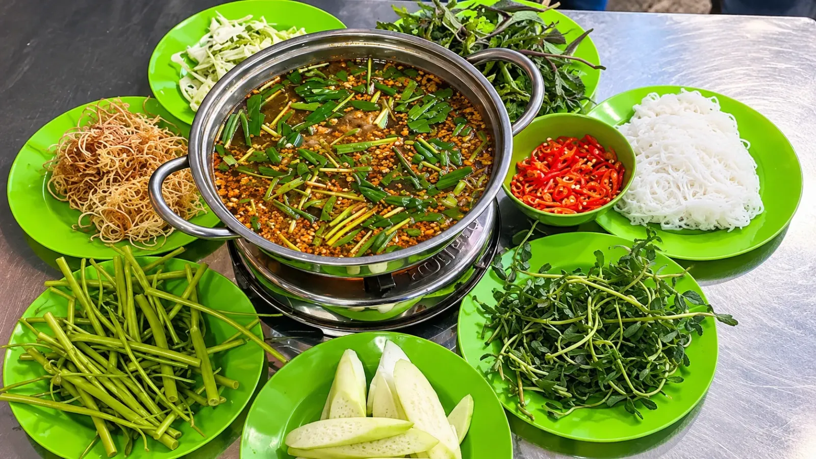 Nồi lẩu cá kèo ăn kèm rau đắng, bông súng và các loại rau nhúng lẩu
