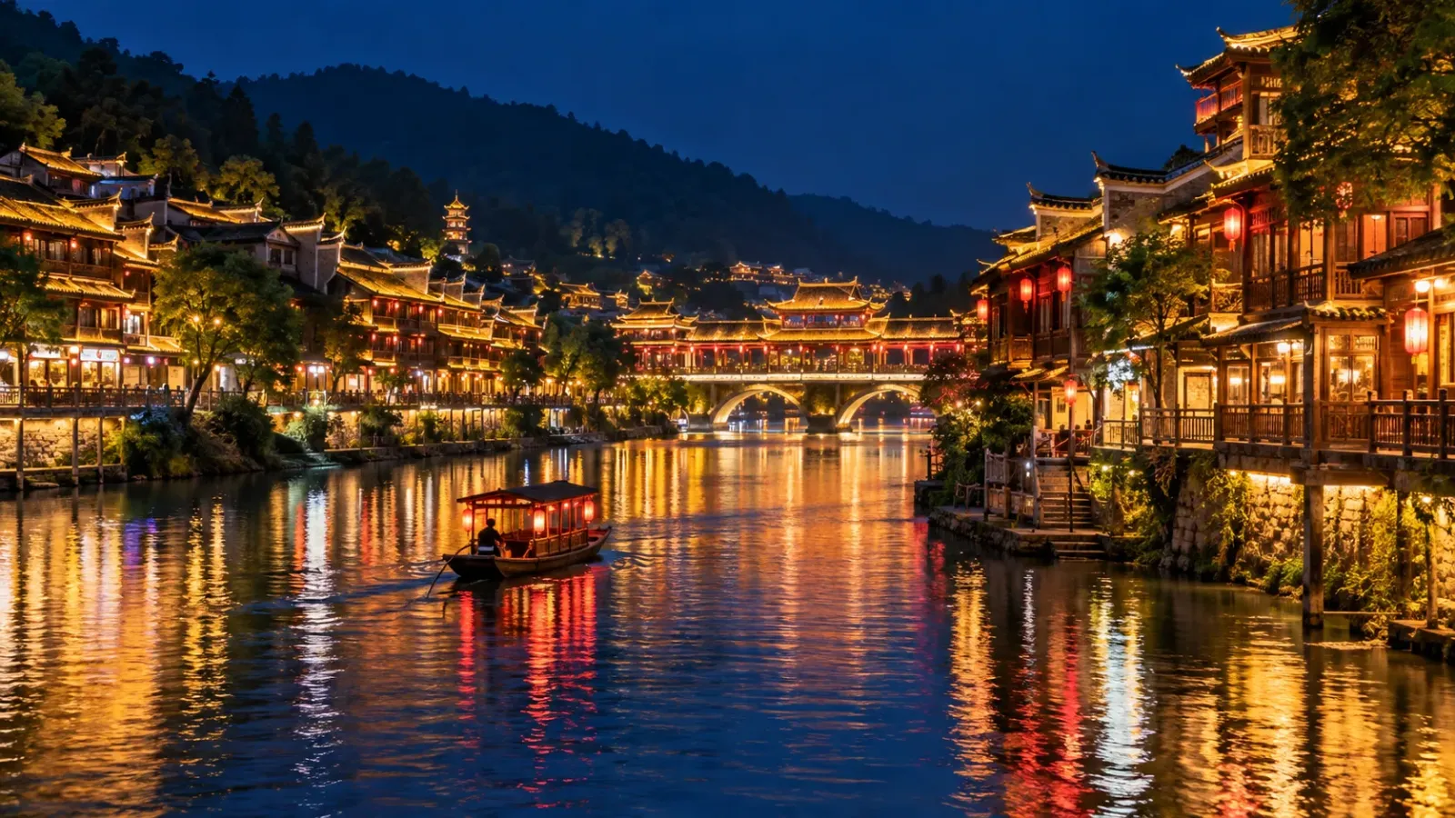 Phượng Hoàng Cổ Trấn vào buổi tối với các ngôi nhà ven sông Đà Giang được thắp sáng và ánh đèn phản chiếu trên mặt nước