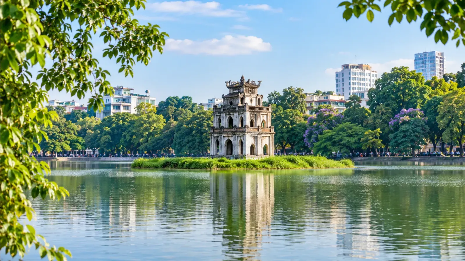 Tháp Rùa giữa hồ Hoàn Kiếm trong khung cảnh cây xanh tại trung tâm Hà Nội.