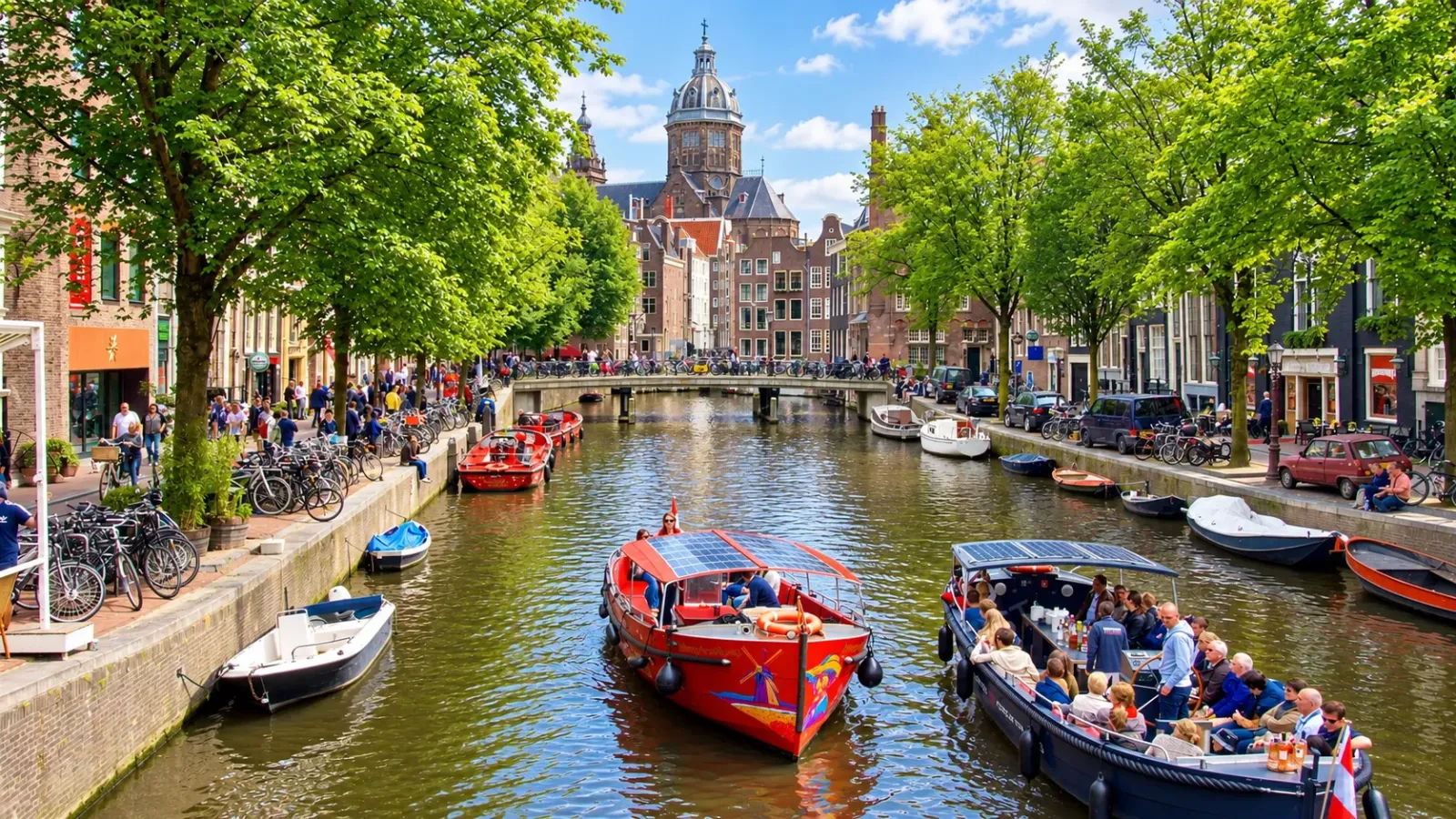 Thuyền du lịch đi qua kênh đào Amsterdam giữa những ngôi nhà cổ và cây cầu