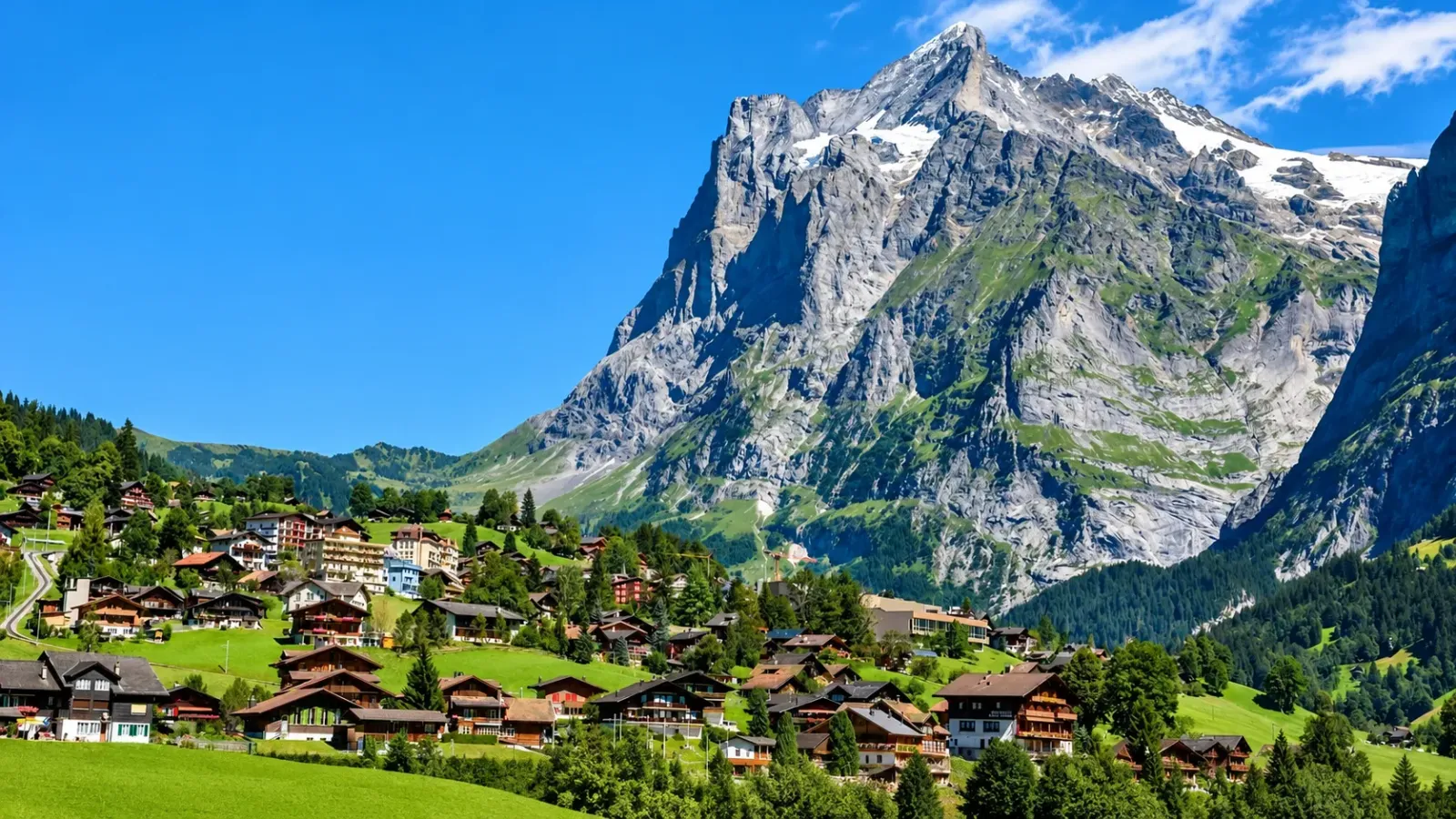 Toàn cảnh làng Grindelwald với nhà gỗ trên đồng cỏ và núi Eiger ở phía sau